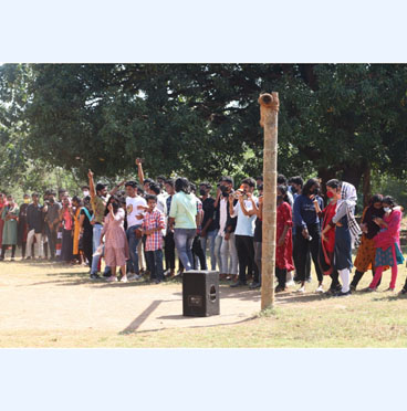 A gathering of students participating in a flash mob event at Jeevani Centre for Students Wellbeing, with many dressed in various colorful outfits, creating awareness about a social cause.